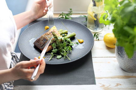A woman is eating a dish at a restaurant.の写真素材