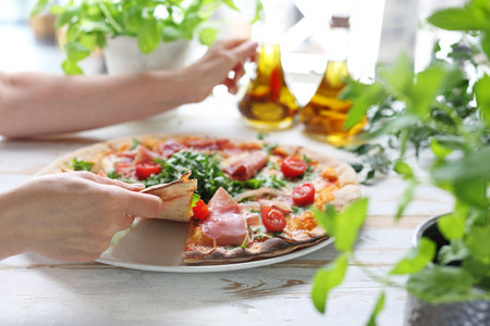 Pizza, traditional Italian pizza on a thin crunchy dough with Parma ham, tomatoes and green rocket salad.の写真素材