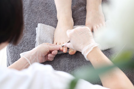 The beautician performs a pedicure treatment.の写真素材