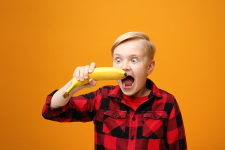 Boy is eating a banana.の写真素材