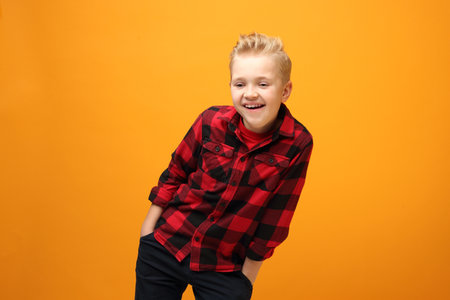 Young handsome smiling caucasian boy in the red shirt on the yellowの写真素材