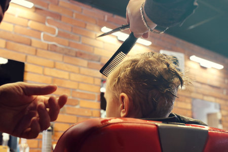Hairdresser. A child, a boy, during a haircut at a barbershop.の写真素材