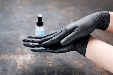 The woman shows the stages of proper hand disinfection with an alcohol-based antibacterial liquid.の写真素材
