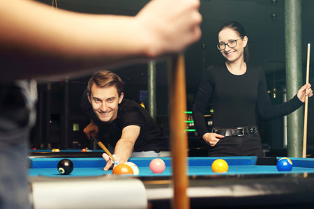 Billiard game. A woman and a man are playing pool in the club