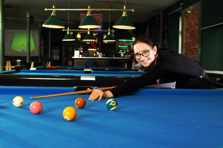 Billiard game. Woman plays billiards in a billiard club.