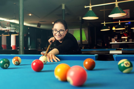 Billiard game. Woman plays billiards in a billiard club.の写真素材