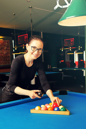 Billiard game. Woman plays billiards in a billiard club.の写真素材