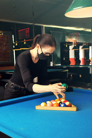 Billiard game. A cup of tea served in black gloves. sanitary regime and protection against infectionの写真素材