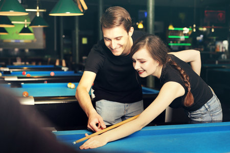 Billiard game. A woman and a man are playing pool in the clubの写真素材