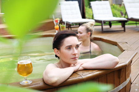 At the spa. Bathing in a spa tub.Two beautiful women enjoy a relaxing bath in the tub. Girl friends at the spa.の写真素材