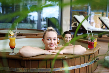 Relax in the hot tub. Two beautiful women enjoy a relaxing bath in the tub. Girl friends at the spa.の写真素材