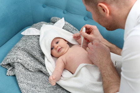Sick baby, mom measures the temperature of the little baby. Care for sick children.の写真素材