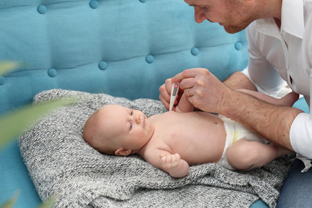 Sick baby, mom measures the temperature of the little baby. Care for sick children.の写真素材