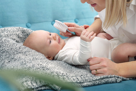 Baby care. A young parent is brushing his baby.の写真素材