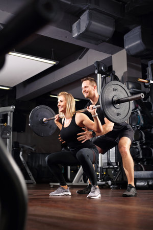Training in the gym. The woman trains with a personal trainer.の写真素材