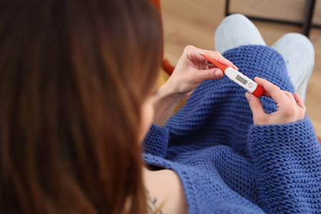 Natural methods of pregnancy planning. Temperature measurement. The woman measures the temperature....