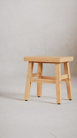 Wooden stool on a gray background with copy space for text.