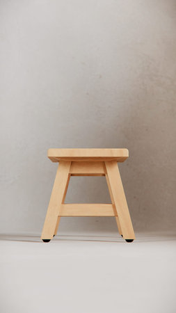 Wooden stool in front of a gray wall, low angle view