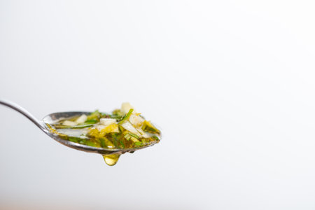 Detail of barbecue marinade on small spoon with white backgroundの写真素材