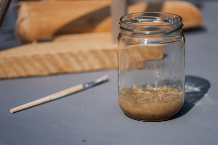 Glas with bone glue soaking in water standing on grey tableの写真素材