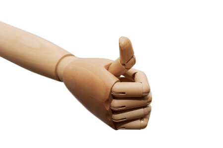 Right hand of wooden dummy mannequin showing thumbs up signal on white backgroundの写真素材