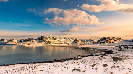 Scenic view over the sand beach near the village Fredvang while hiking in Ytresand on the Lofoten islands archipelago in Norway in golden sunlight on clear winter dayの写真素材
