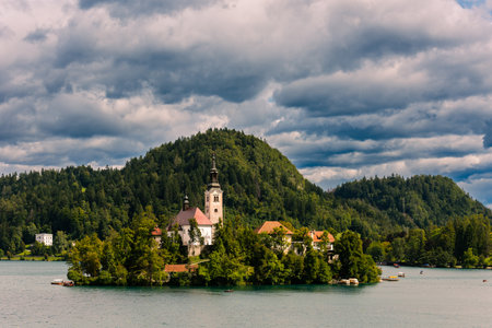 The Pilgrimage Church of the Assumption of Maria on a small island in the Lake Bled in Slovenia in late summer on a day with dramatic cloudsのeditorial素材