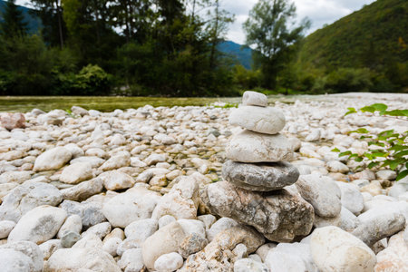 Small river with white round stones on the riverbanks in the Triglav National Park in Slovenia on cloudy autumn dayの写真素材