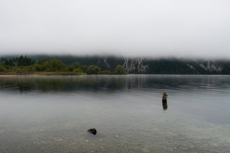 The beautiful Lake Bohinj in the Triglav National Park in Slovenia on misty morning in autumnの写真素材
