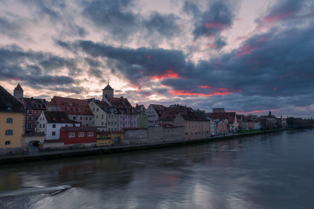 Panoramic view of the famous skyline of Regensburg in Bavaria seen from the Stone Bridge with dramatic clouds in evening skyの写真素材