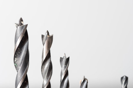 Detail of set of various drills in different sizes for wood, iron and concrete materials collocated together isolated on white backgroundの写真素材