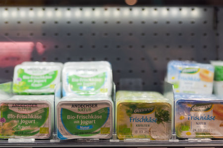 Regensburg, Germany - 2021 02 05: Refrigerated section with packs of cream cheese of brands Andechser and dennree behind glass doors on display in German organic super marketのeditorial素材