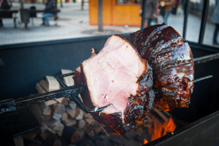 Czech specialty grilled and glaced ham over wooden fire pit in Pragueの写真素材