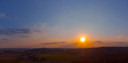 Aerial drone panorama of the village Eichlberg near Hemau with church of pilgrimage and surrounding rural area on top of a hill in Bavaria in sunlightの写真素材