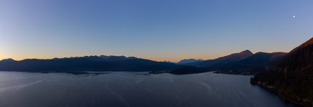 Epic drone panorama of mountain lake Walchensee in Bavaria, Germany in early dawn with alpine mountains andfull moonの写真素材