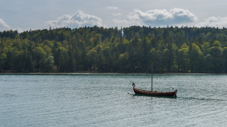 Replica of viking dragon boat for movie in mountain lake Walchensee in Bavaria, Germany on sunny dayの写真素材