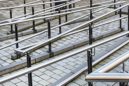 Urban paved footpath with a maze of silver handrail