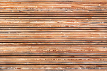 Slightly weathered wooden facade of a house with horizontal battens and silver screwsの写真素材