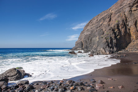 Lonely beach with black sand and impressive rock backdrop at the Playa del Trigo near Alojera in the west of La Gomera, Canary Iceland, Spain.の写真素材