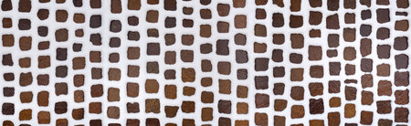 Snowy cobblestone pavement made of brown and gray stones - panoramic detail in high angle view