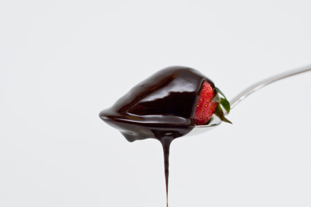 Strawberrie in spoon with chocolate isolated on white backgroundの写真素材
