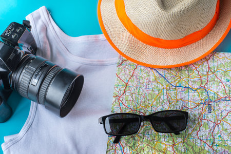 Travel kit: hat, camera, map, t-shirt and sun glasses. Flat lay composition for social media and travelers. overhead viewの写真素材
