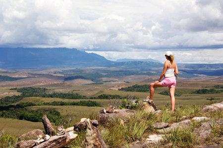 Women tourist looking at table-top mountains called Tepui in background, Gran Sabana, Guayana Highlands, Venezuela, South America. Events of novel of A.Conan-Doyle The Lost World took place hereの写真素材