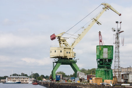 Big crane in port under pale gray sky