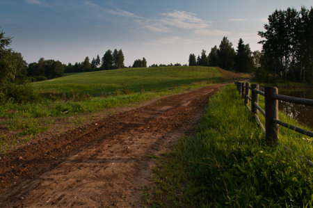 Rural road in early morning with hill in backgroundの写真素材