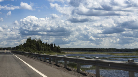 Highway, Pond, Trees and Cloudy Blue Sky in Eastern Newfoundland, Canadaの写真素材