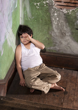 Frightened Boy in White Undershirt and Khaki Pantsの写真素材