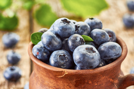 Fresh blackberries in ceramic cup on wooden table. Rustic style.の写真素材