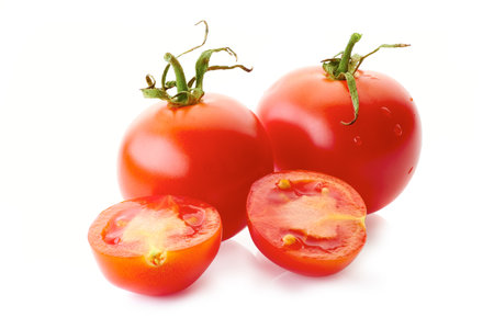 Two red tomatoe with halfs isolated on white backgroundの写真素材