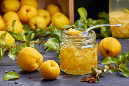Syrup of japanese quince on fresh fruits background over dark wooden table.の写真素材